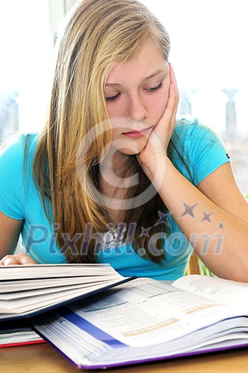 Teenage girl studying with textbooks looking unhappy