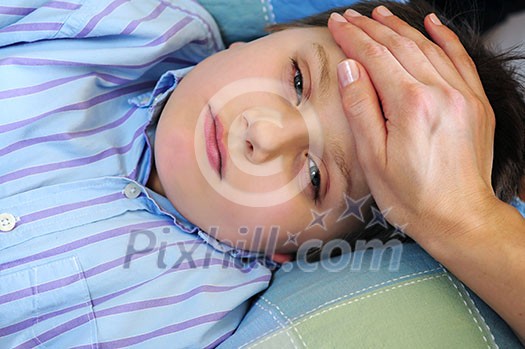 Mother's hand feeling the forehead of a sick child