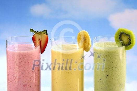 Assorted fruit and berry smoothies on blue sky background