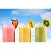 Assorted fruit and berry smoothies on blue sky background