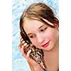 Portrait of a teenage girl with large tropical seashell