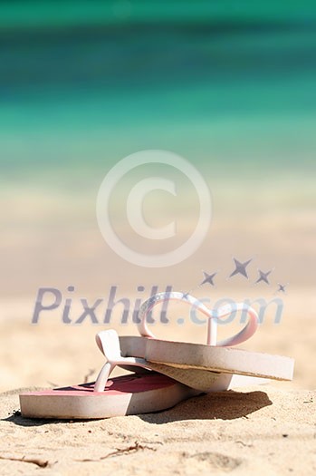 Flipflops on a sandy ocean beach - vacation concept Flipflops on a sandy ocean beach - vacation concept