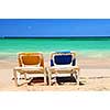 Two vacation chairs on sandy beach of Caribbean island