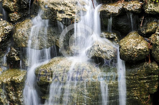 Waterfall over natural stones in japanese zen garden Waterfall over natural stones in japanese zen garden