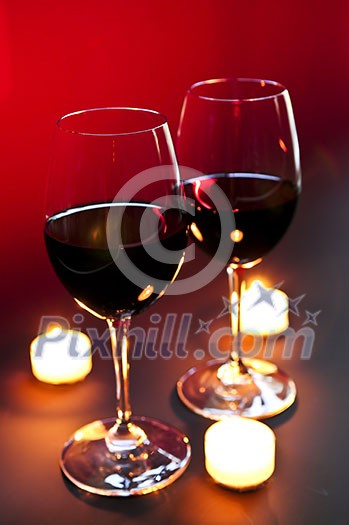 Two wineglasses with red wine at candlelight