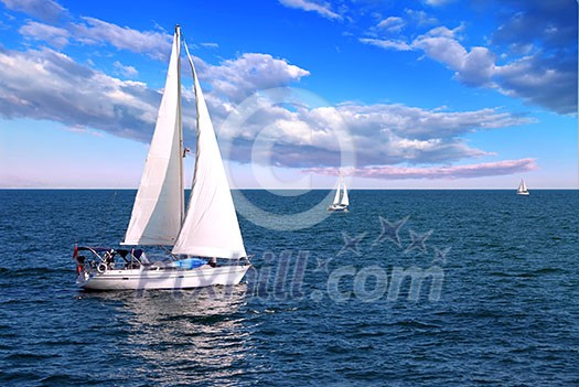 Sailboat sailing in the morning with blue cloudy sky