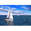 Sailboat sailing in the morning with blue cloudy sky