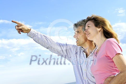 Mature romantic couple of baby boomers looking at the sky Mature romantic couple of baby boomers looking at the sky