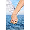 Mature romantic couple holding hands on the beach