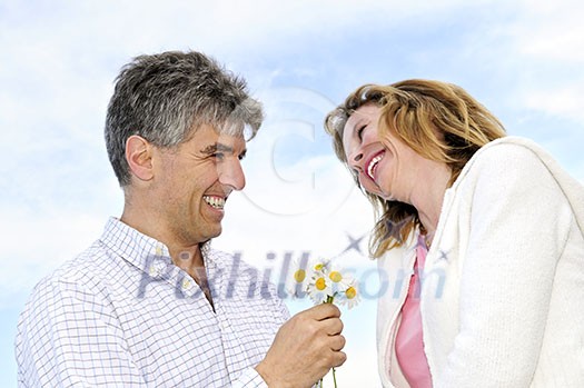 Mature couple enjoying a romantic moment with flowers Mature couple enjoying a romantic moment with flowers