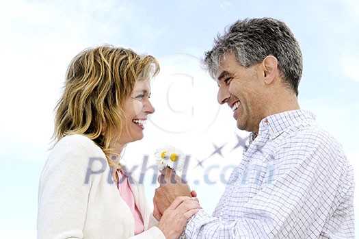 Mature couple enjoying a romantic moment with flowers Mature couple enjoying a romantic moment with flowers