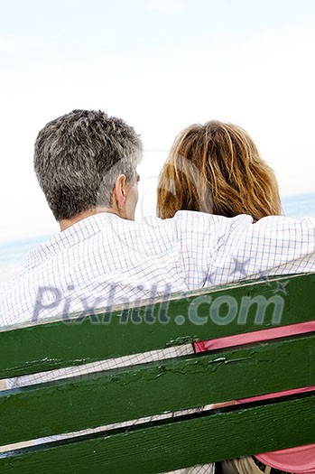 Mature romantic couple on a bench on seashore