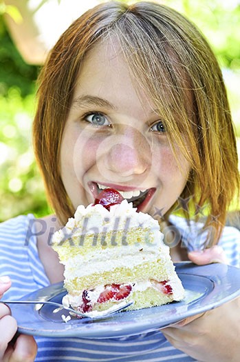 Teenage girl eating a piece of strawberry cake