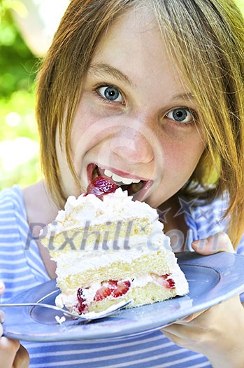 Teenage girl eating a piece of strawberry cake