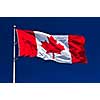 Flag of Canada waving in the wind on blue sky background