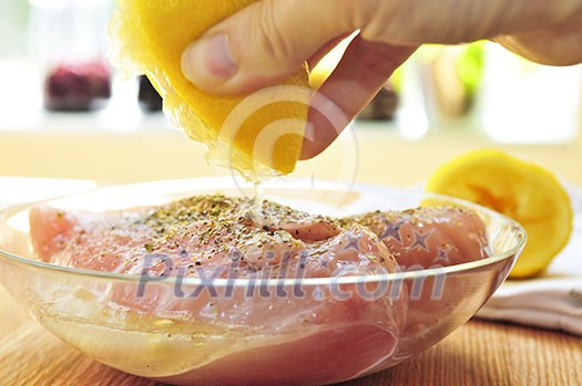 Marinating raw chicken breasts in lemon juice and herbs Marinating raw chicken breasts in lemon juice and herbs