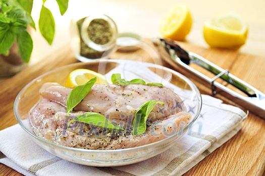 Marinating raw chicken breasts in lemon juice and herbs Marinating raw chicken breasts in lemon juice and herbs