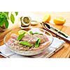 Marinating raw chicken breasts in lemon juice and herbs