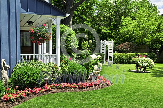 Landscaped front yard of a house with flowers and green lawn Landscaped front yard of a house with flowers and green lawn
