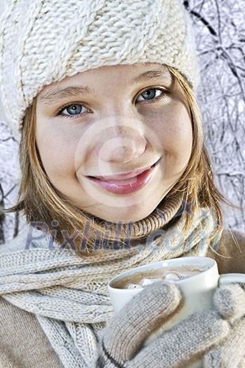 Teenage girl in winter hat with cup of hot chocolate