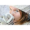 Teenage girl in winter hat with cup of hot chocolate