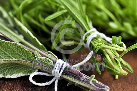 Bunches of assorted fresh herbs close up on wooden cutting board Bunches of assorted fresh herbs close up on wooden cutting board
