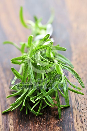 Bunch of fresh herb rosemary close up on wooden cutting board Bunch of fresh herb rosemary close up on wooden cutting board