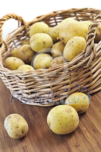 Yellow raw potatoes in a basket close up