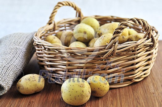 Yellow raw potatoes in a basket close up