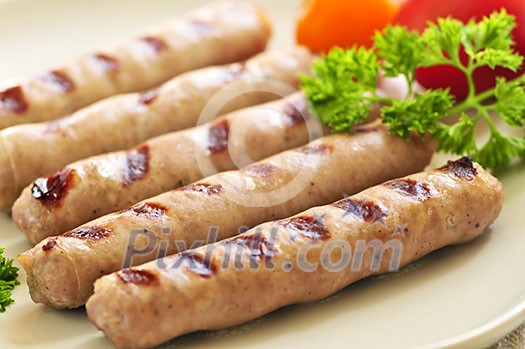 Serving of grilled breakfast sausages on a plate Serving of grilled breakfast sausages on a plate