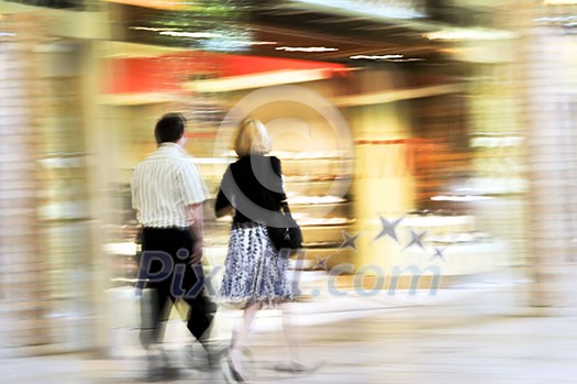 Couple shopping in a mall, panning shot, intentional in-camera motion blur Couple shopping in a mall, panning shot, intentional in-camera motion blur