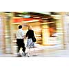 Couple shopping in a mall, panning shot, intentional in-camera motion blur