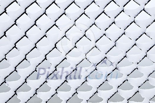 Pattern of chain link fence under fresh snow