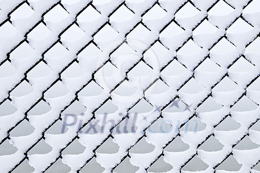 Pattern of chain link fence under fresh snow Pattern of chain link fence under fresh snow