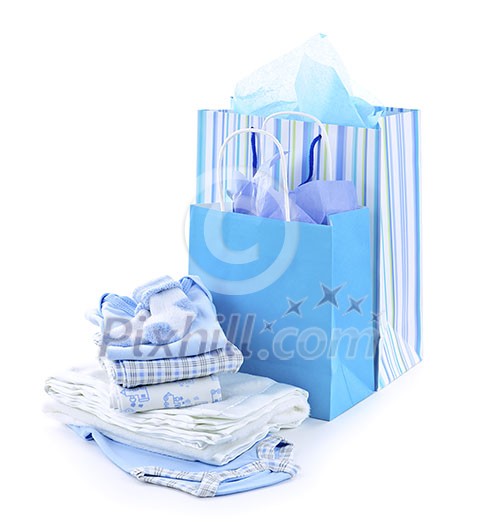 Gift bags and infant clothes for baby shower isolated on white