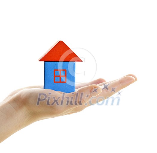 Hand holding wooden block house isolated on white background