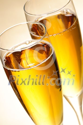 Two full champagne flutes with sparkling wine