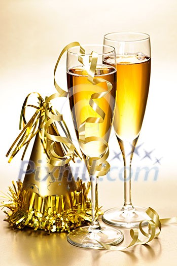 Two full champagne flutes with party hat and ribbons