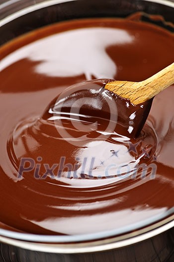 Wooden spoon stirring soft melted rich chocolate Wooden spoon stirring soft melted rich chocolate