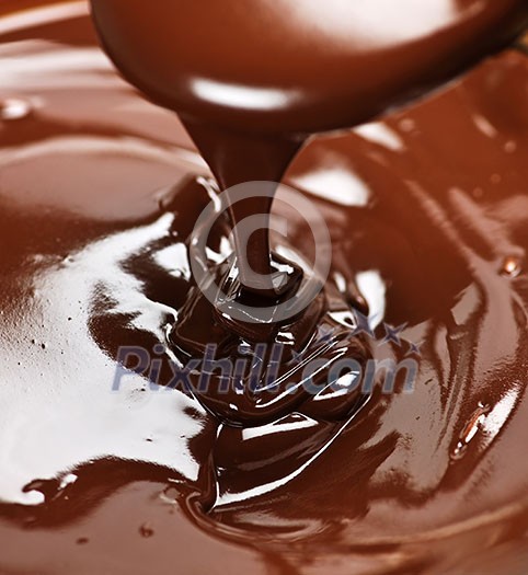 Melted rich dark chocolate dripping from spoon