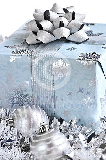 Wrapped gift box with Christmas ornaments on white background
