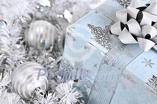 Wrapped gift box with silver Christmas ornaments