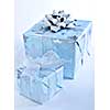 Two christmas gift boxes wrapped in blue paper with silver ribbon