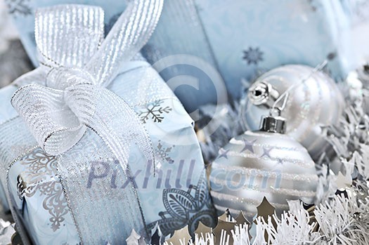 Wrapped gift boxes with silver Christmas ornaments