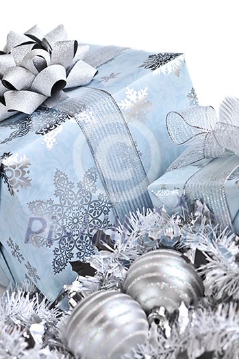 Wrapped gift boxes with silver Christmas ornaments on white background