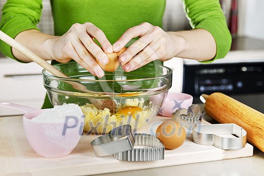 Cracking egg into mixing bowl making cookies Cracking egg into mixing bowl making cookies
