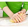 Hands kneading ball of dough with flour on cutting board