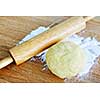 Wooden rolling pin and ball of cookie dough with flour