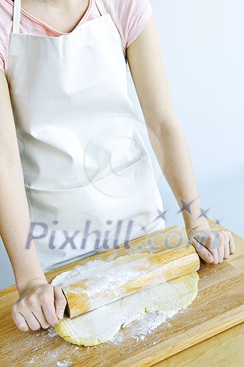 Spreading out cookie dough with wooden rolling pin Spreading out cookie dough with wooden rolling pin
