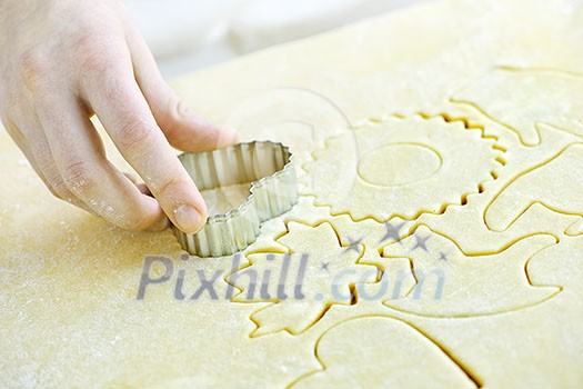 Cutting cookie shapes in rolled dough with cutter